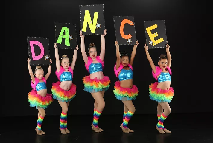 dancers in costume holding dance sign